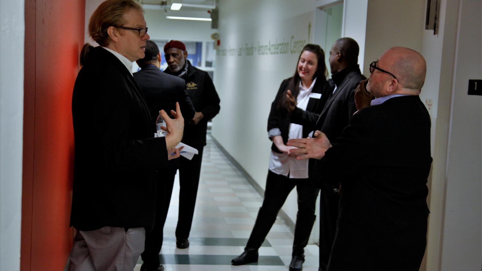 TEC staff + visitors talk in hallway