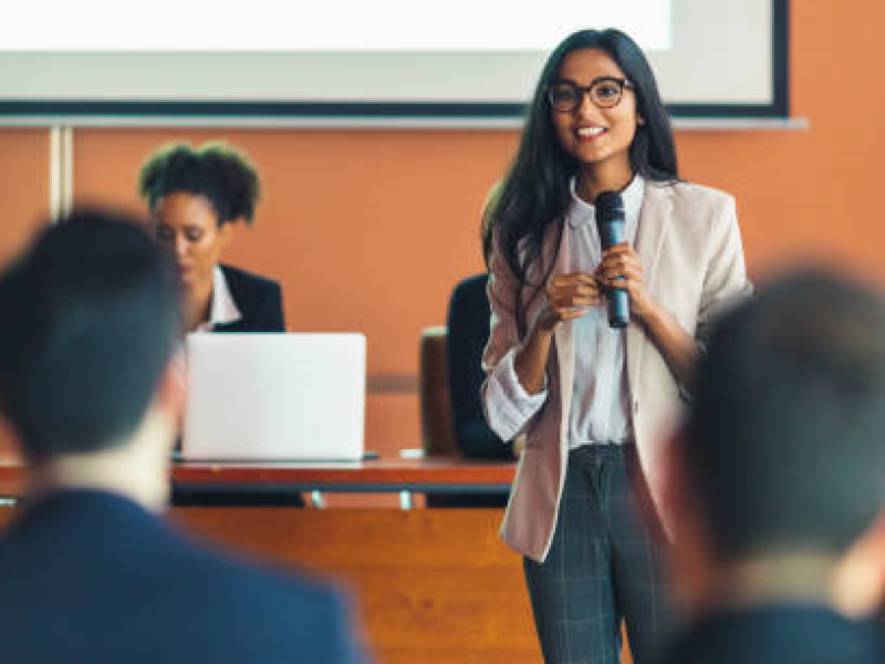 Woman speaking into microphone, conference